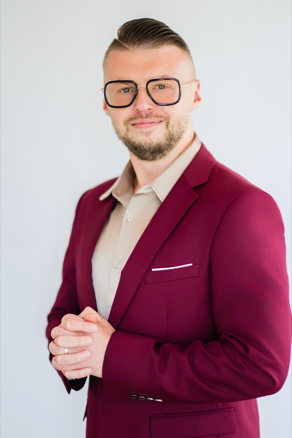 Eugene Berezin, MA, Registered
          Hypnotherapist, in a burgundy suit with his hands clasped